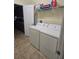 Convenient laundry room with a washer, dryer, and shelving for storage and open doorway to the kitchen at 8923 Cuban Palm Rd, Kissimmee, FL 34747