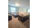 Comfortable living room featuring a large window, plush seating, and neutral carpeting at 8923 Cuban Palm Rd, Kissimmee, FL 34747