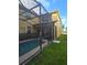 Exterior view of a screened-in pool and patio area, surrounded by a well-manicured lawn at 8923 Cuban Palm Rd, Kissimmee, FL 34747