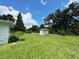 Spacious backyard featuring a storage shed with lush green grass and blue skies at 1400 E Fern Rd, Lakeland, FL 33801