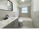Updated bathroom features gray vanity with white sink and shower-tub combo at 1400 E Fern Rd, Lakeland, FL 33801