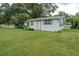 Exterior view of house with lush green grass, mature trees, and a well-maintained lawn at 1400 E Fern Rd, Lakeland, FL 33801