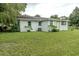 Exterior view of house with lush green grass, mature trees, and a well-maintained lawn at 1400 E Fern Rd, Lakeland, FL 33801