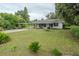 Quaint single story home with mature trees, green lawn and attached carport at 1400 E Fern Rd, Lakeland, FL 33801