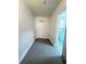 Hallway features a neutral color palette and white door, and view to the washer dryer area at 1400 E Fern Rd, Lakeland, FL 33801