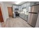Contemporary kitchen showcasing gray cabinets, stainless steel appliances, and gray wood flooring at 1400 E Fern Rd, Lakeland, FL 33801
