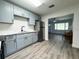 Updated kitchen with gray cabinets, stainless steel appliances, and gray wood flooring at 1400 E Fern Rd, Lakeland, FL 33801