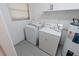 Functional laundry room with washer, dryer, water heater, and shelving for ample storage at 1400 E Fern Rd, Lakeland, FL 33801