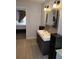 Modern bathroom with dual sinks, wood cabinets, and decorative mirror at 7607 Benji Ridge Trl, Kissimmee, FL 34747