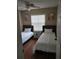 Cozy bedroom featuring twin beds, wood floors, a ceiling fan, and natural light from the window at 7607 Benji Ridge Trl, Kissimmee, FL 34747