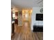 Open living room with wood floors, modern lighting, and access to the kitchen and hallway at 7607 Benji Ridge Trl, Kissimmee, FL 34747