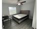 Bedroom with grey hardwood floors, a modern bed, a desk, and a sunlit window at 4041 Se 20Th Ct, Ocala, FL 34480