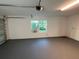 Bright and spacious garage featuring painted walls and floor, a window, and an updated garage door at 4041 Se 20Th Ct, Ocala, FL 34480