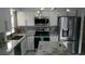 Updated kitchen showcasing granite countertops, stainless appliances, and modern white cabinetry at 4041 Se 20Th Ct, Ocala, FL 34480