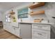 Stylish kitchen featuring stainless steel appliances, white cabinetry, and open wooden shelving at 5324 Messina, Lakeland, FL 33813