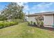 Side yard with lush landscaping, green grass, privacy fence, and a flower tree at 5324 Messina, Lakeland, FL 33813