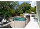 Backyard pool featuring lush landscaping, a waterfall feature, and privacy fencing at 643 Blenheim Loop, Winter Springs, FL 32708