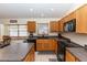 Features light wood cabinets, black appliances, an island with bar seating, and backsplash at 643 Blenheim Loop, Winter Springs, FL 32708