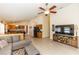 Open-concept living room and kitchen featuring tile floors, ceiling fan, and ample natural light at 643 Blenheim Loop, Winter Springs, FL 32708