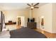 Spacious bedroom featuring a ceiling fan, wood floors, and a view of the ensuite bathroom at 643 Blenheim Loop, Winter Springs, FL 32708