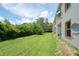 Wide view of a grassy backyard with lush green trees bordering the unit at 946 15Th St # 202, Daytona Beach, FL 32117