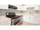 Well-lit kitchen showcases white cabinets, quartz countertops, stainless appliances, and new floors at 946 15Th St # 202, Daytona Beach, FL 32117