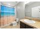 Bathroom features a tub with a scenic shower curtain, tile flooring, and a granite vanity at 303 Briarbrook Ln, Haines City, FL 33844