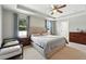 Bright main bedroom features a tray ceiling, neutral tones, and a large window with a view at 303 Briarbrook Ln, Haines City, FL 33844