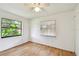 A bright bedroom featuring hardwood flooring with two windows and a ceiling fan at 5455 Pinetrail Way, Orlando, FL 32822
