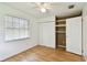 A bright bedroom featuring hardwood flooring and a closet with double doors at 5455 Pinetrail Way, Orlando, FL 32822