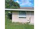A house's exterior features a window with blinds and a doorway, presenting a simple architectural design at 5455 Pinetrail Way, Orlando, FL 32822