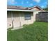 Exterior view of a home featuring a door, window, and a weathered fence, showing its outdoor structure at 5455 Pinetrail Way, Orlando, FL 32822