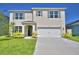 Charming two-story home featuring a well-manicured lawn and light green shutters with complementary front door at 2005 Carnostie Rd, Winter Haven, FL 33884