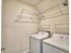 Functional laundry area with washer, dryer, and wire shelving for storage at 2005 Carnostie Rd, Winter Haven, FL 33884