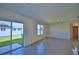 Bright living room with sliding glass doors to backyard and neutral tile flooring throughout at 2005 Carnostie Rd, Winter Haven, FL 33884