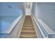 Carpeted staircase with white railing leads to the upper level of the home, providing easy access to bedrooms at 2005 Carnostie Rd, Winter Haven, FL 33884