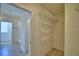 Walk-in closet featuring an adjustable shelving system and neutral carpet offering ample storage to stay organized at 2005 Carnostie Rd, Winter Haven, FL 33884