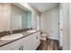 Bathroom featuring double sinks, white cabinetry, and wood-look flooring at 762 Ambleside Dr, Haines City, FL 33844
