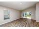 Bright bedroom with wood-look floors, neutral walls, a window, and sliding glass doors to the backyard at 762 Ambleside Dr, Haines City, FL 33844