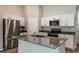 Modern kitchen with stainless steel appliances, gray countertops, island with sink, and white cabinets at 762 Ambleside Dr, Haines City, FL 33844