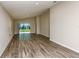 Inviting living room with wood-look floors, neutral walls, and sliding glass doors to the backyard at 762 Ambleside Dr, Haines City, FL 33844
