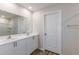 Modern bathroom with double sinks, white cabinets, and wood-look flooring at 3730 King Hill Dr, Haines City, FL 33844