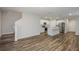 Open-concept living area with wood-look flooring, kitchen, and stairway to the second floor at 3730 King Hill Dr, Haines City, FL 33844