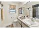 Bright bathroom with white cabinets, matching framed mirror and tiled shower at 6642 Parson Brown Dr, Orlando, FL 32819