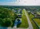 A view of a white single-Gathering home in a suburban neighborhood surrounded by lush green trees at 1430 Tern Ct, Poinciana, FL 34759