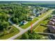 Aerial view of home nestled on a tree-lined street and lush green lawn at 1430 Tern Ct, Poinciana, FL 34759