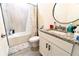 The bathroom offers a granite countertop, modern vanity, and tiled shower-tub combo at 1430 Tern Ct, Poinciana, FL 34759