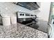 A granite countertop and stainless steel stove top within a modern kitchen at 1430 Tern Ct, Poinciana, FL 34759
