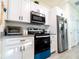 Kitchen showcasing stainless steel appliances, white cabinets and granite countertops at 1430 Tern Ct, Poinciana, FL 34759