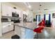 Modern kitchen with granite countertops, stainless steel appliances, white cabinets and red bar stools at 1430 Tern Ct, Poinciana, FL 34759